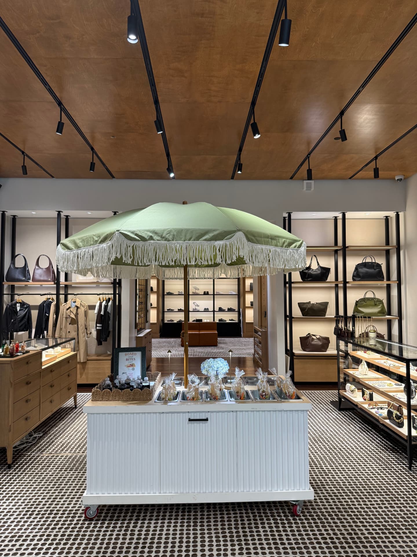 The cart styled inside a luxury retail boutique under a fringed umbrella